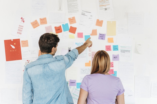 young-employees-looking-wall-with-marketing-notes_23-2148222645